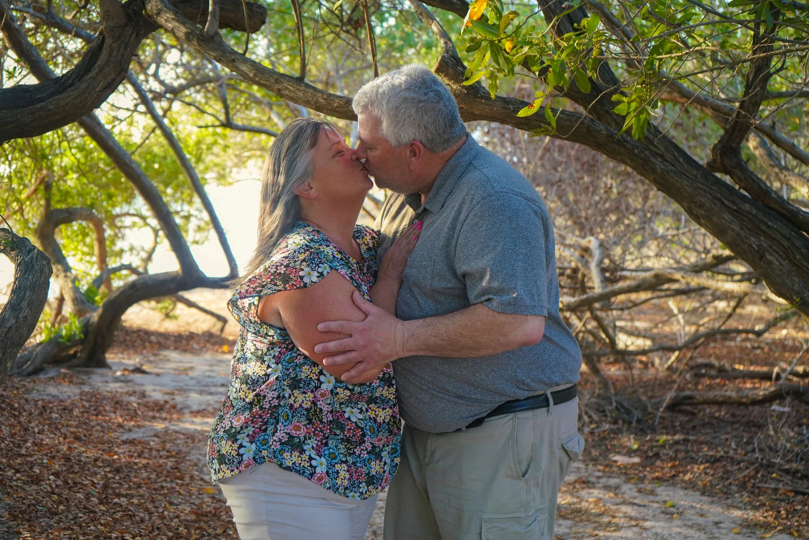 Couple kissing under the trees by the beach in Aruba