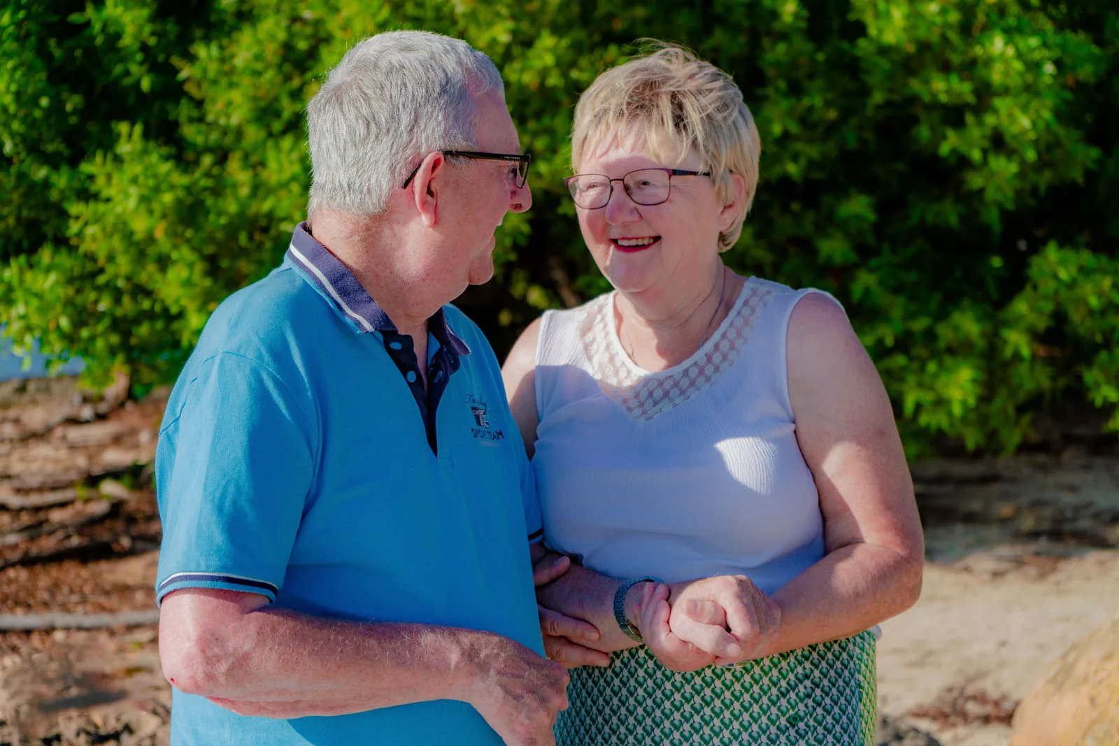 Couple holding hands and smiling at each other on the beach in Aruba
