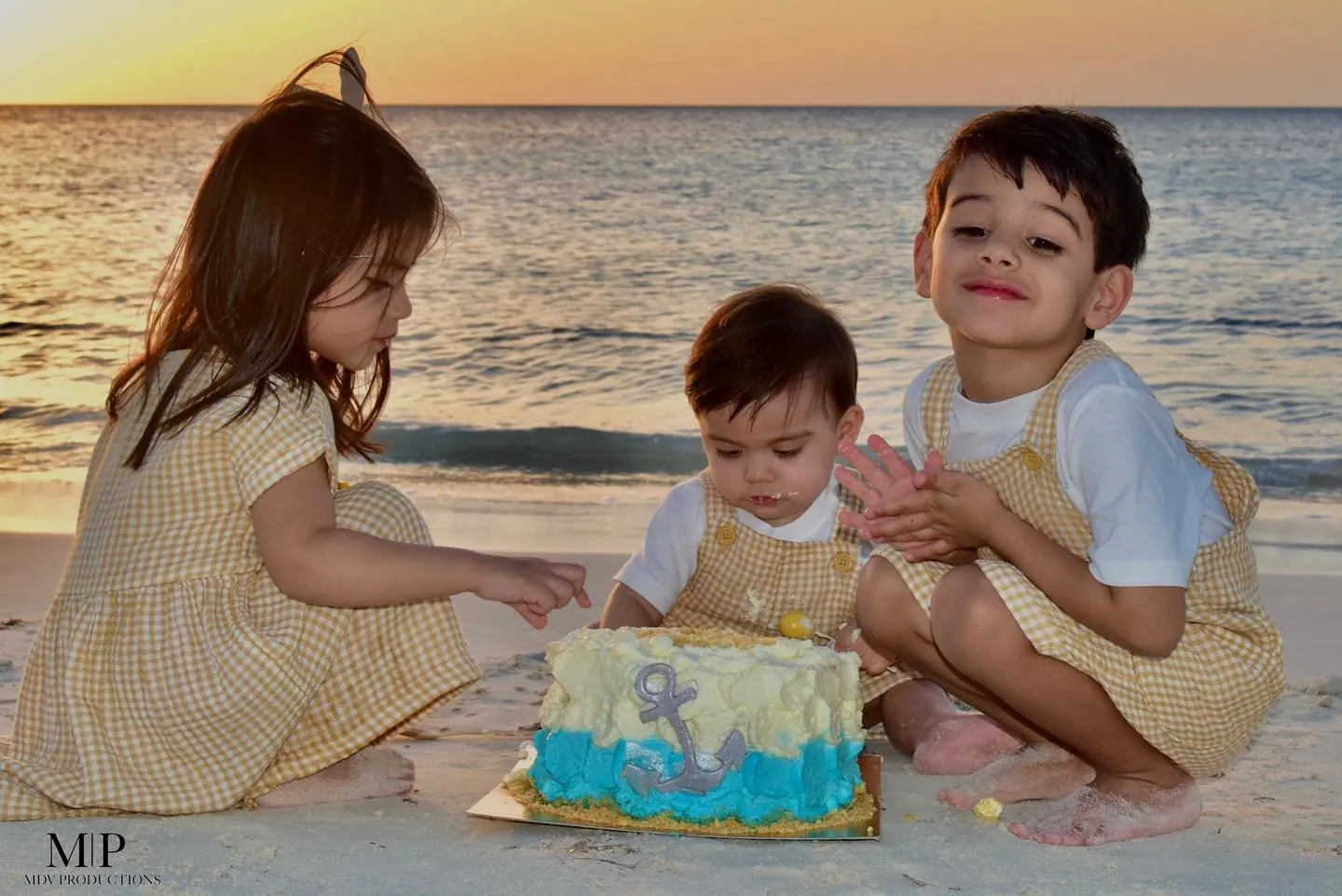 Three children with a birthday cake on the beach in Aruba