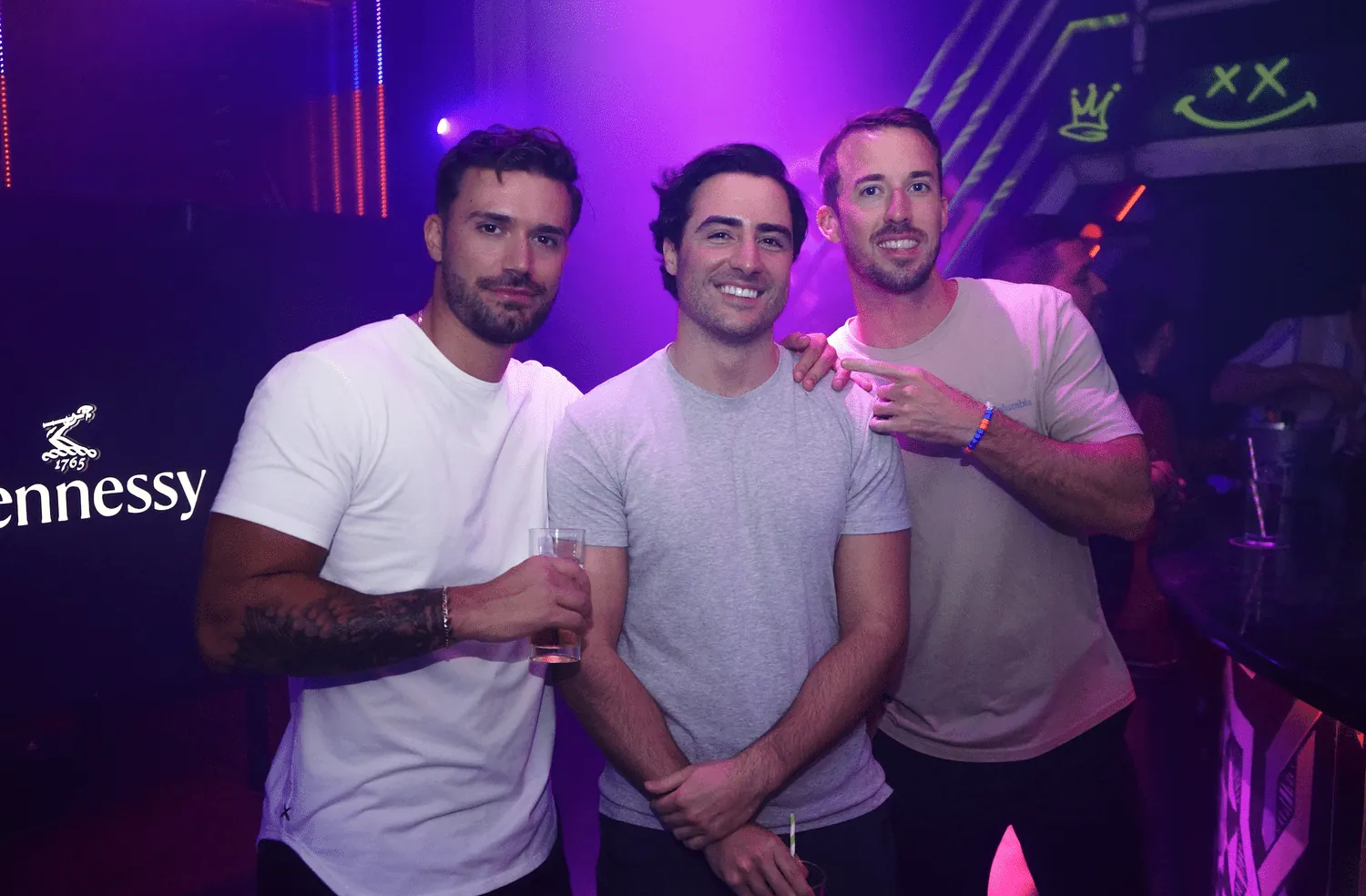 Three friends at a club night under purple lights in Aruba