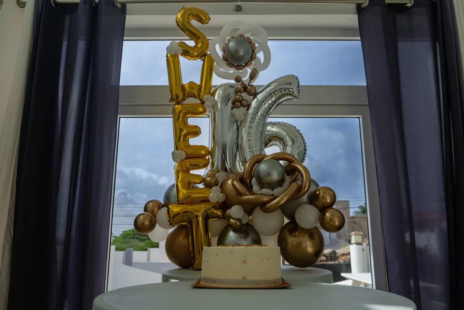 Sweet 16 balloon arrangement in gold and silver at a party in Aruba