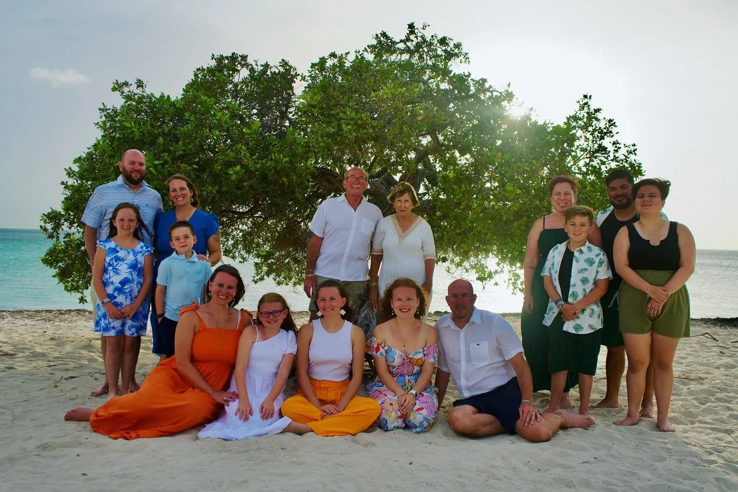 Large family group on the beach under a big tree in Aruba