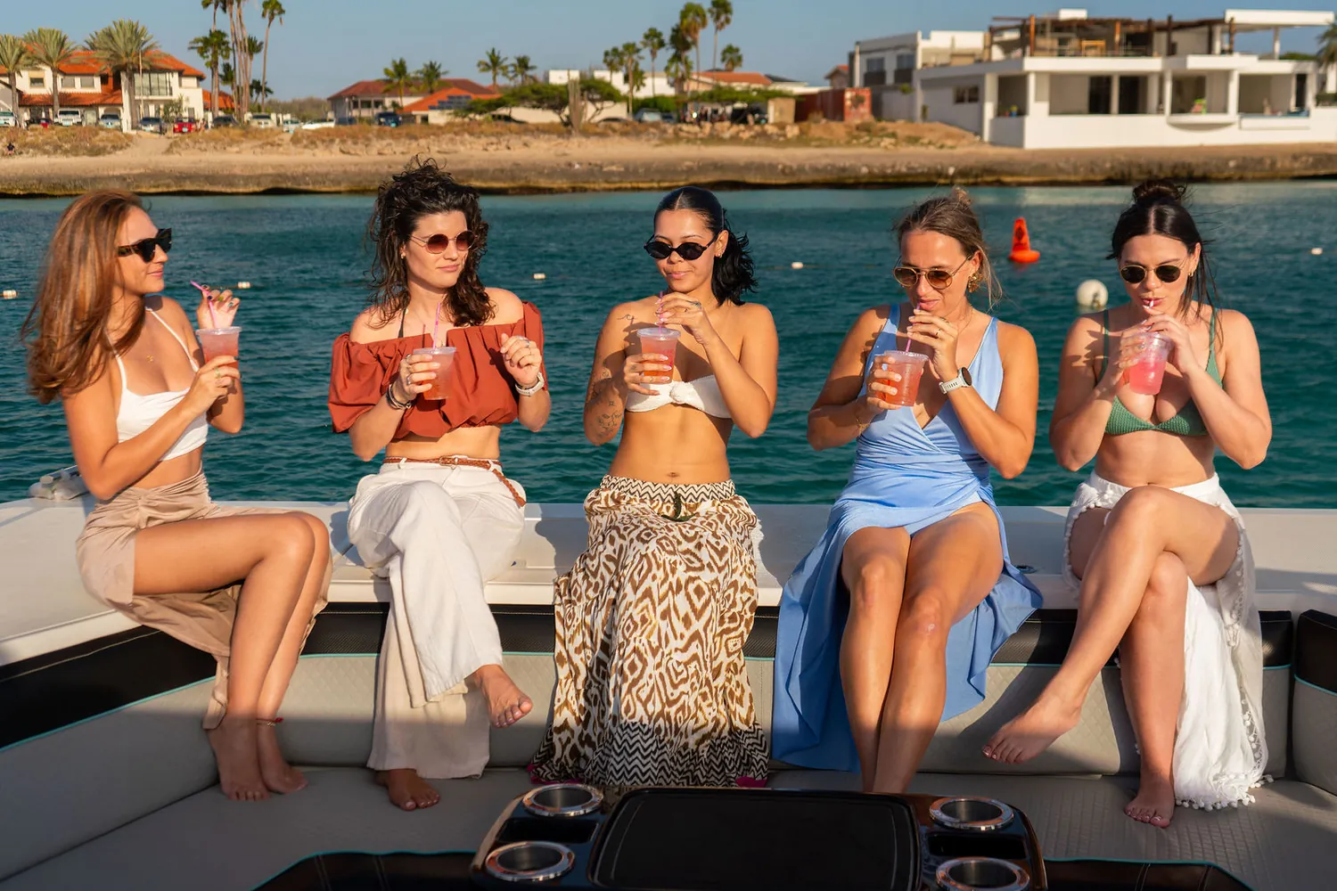Five friends with cocktails on a boat day along the Aruba coast