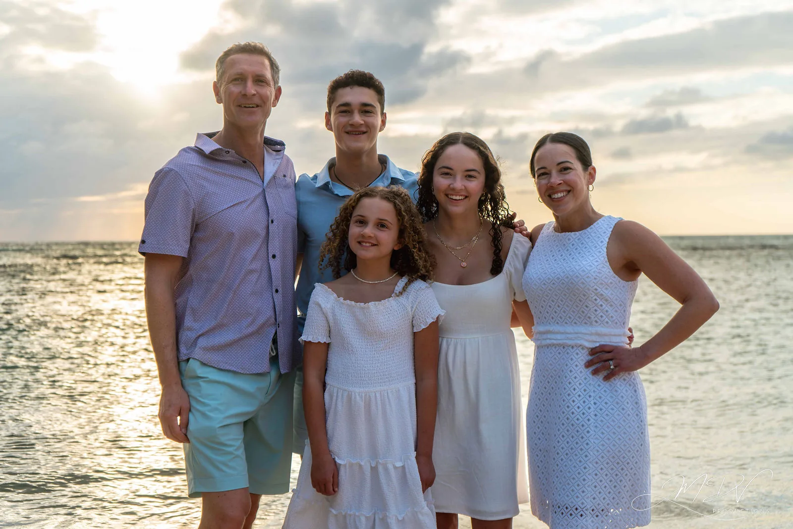 Parents with their three children by the sea at sunset in Aruba