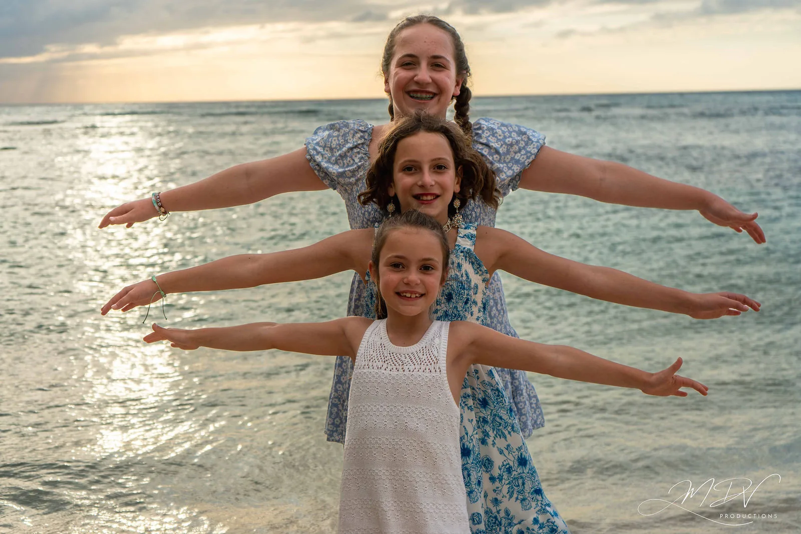 Three sisters stretching out their arms in the sea in Aruba