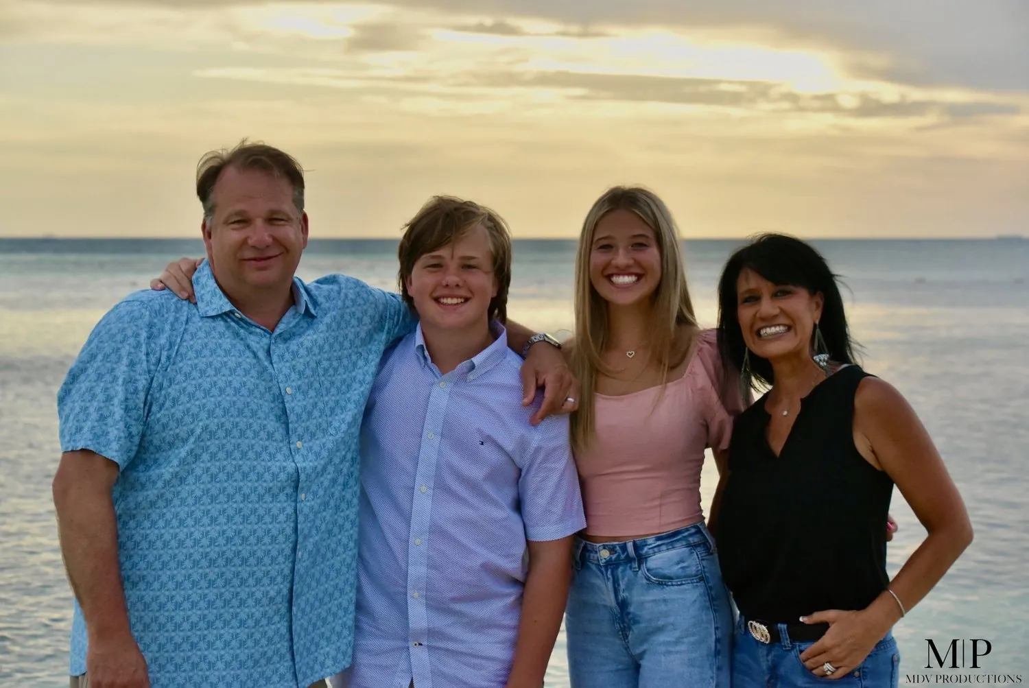 Family of four with two teenagers on the beach at sunset in Aruba