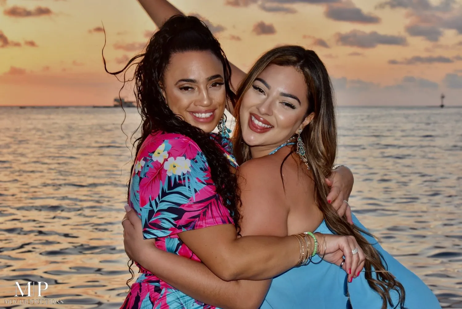 Two friends hugging on the beach at sunset in Aruba