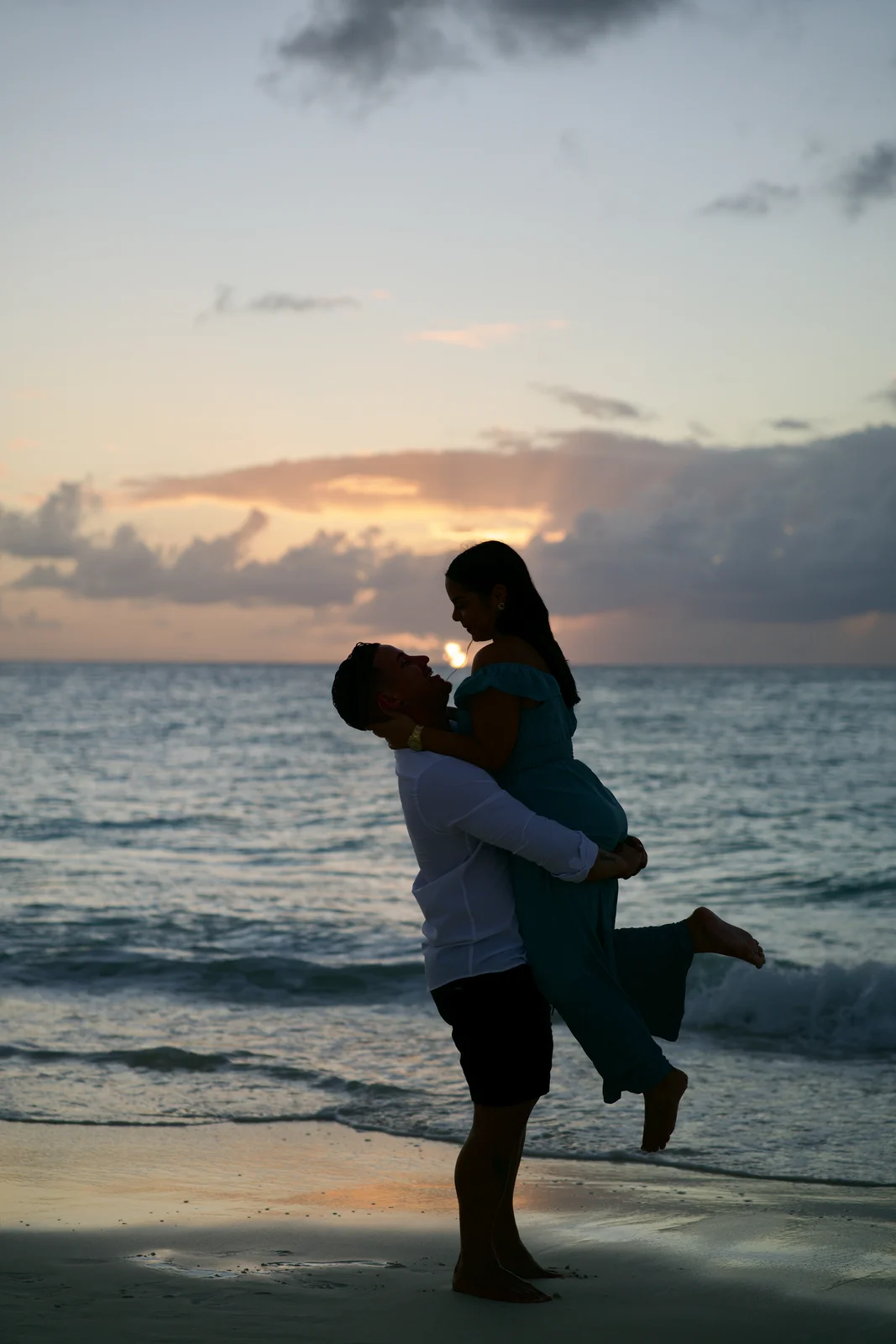 Couple embracing by the sea at sunset in Aruba