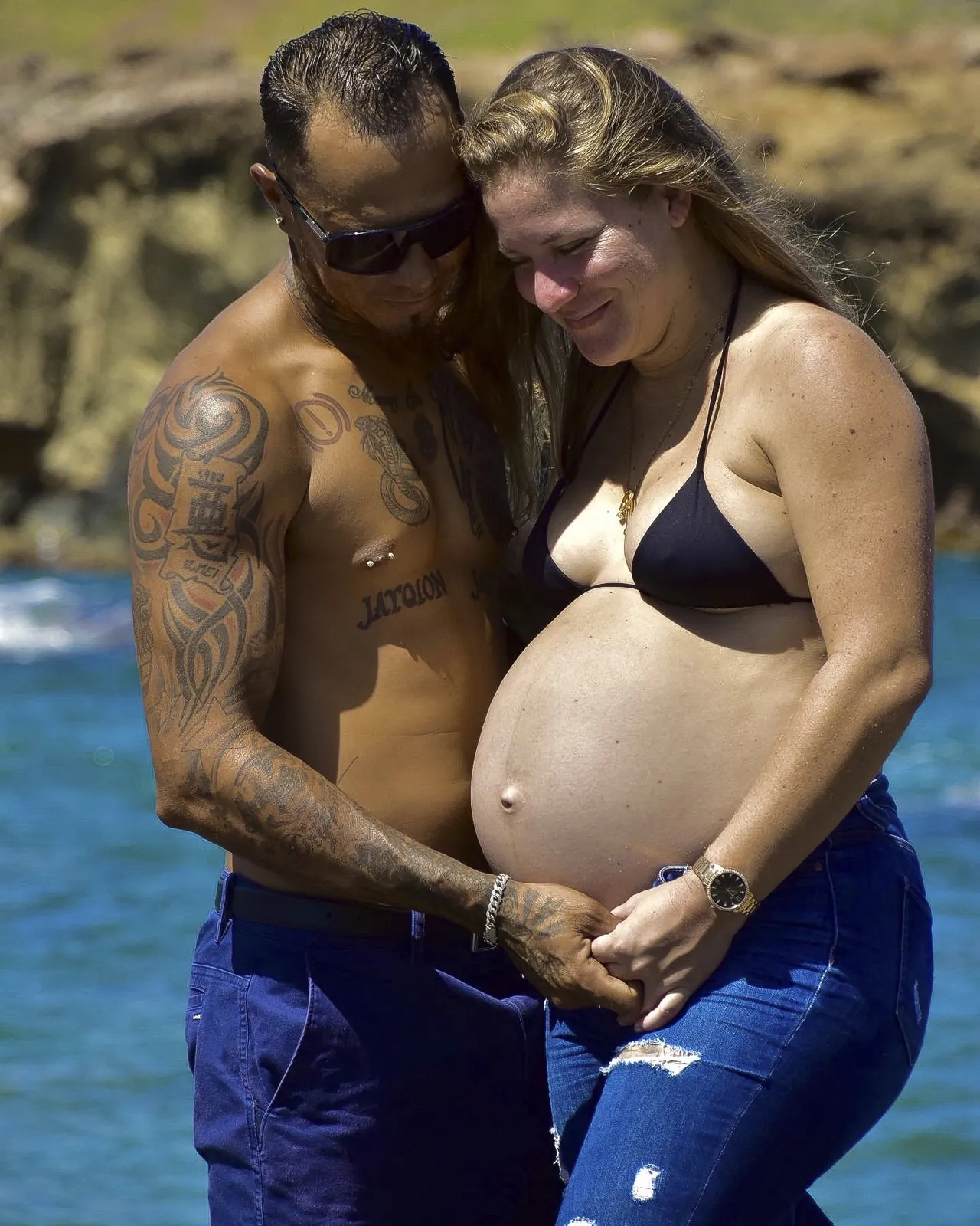 Expecting couple holding the belly together by the sea in Aruba