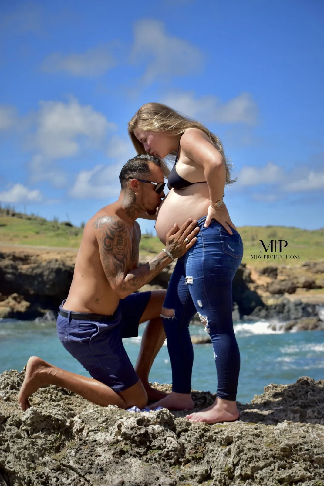 Partner kneeling on the rocks to kiss the belly in Aruba