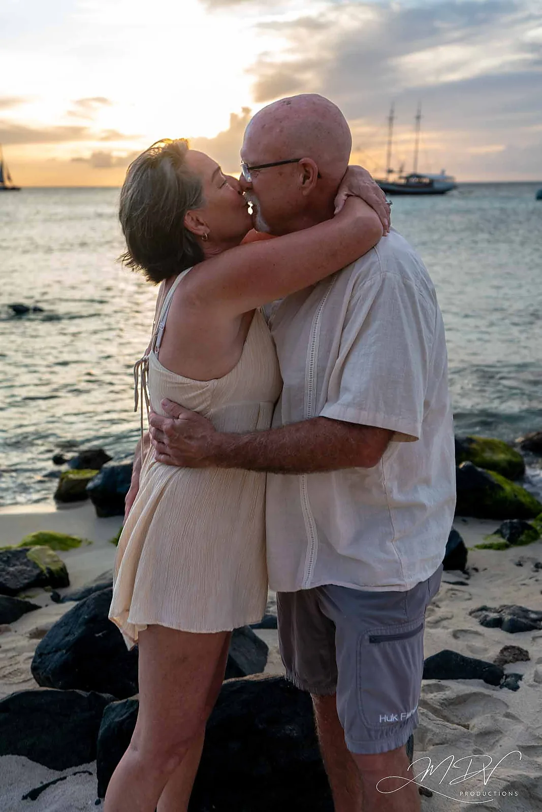 Newly engaged couple kissing on the beach at sunset in Aruba