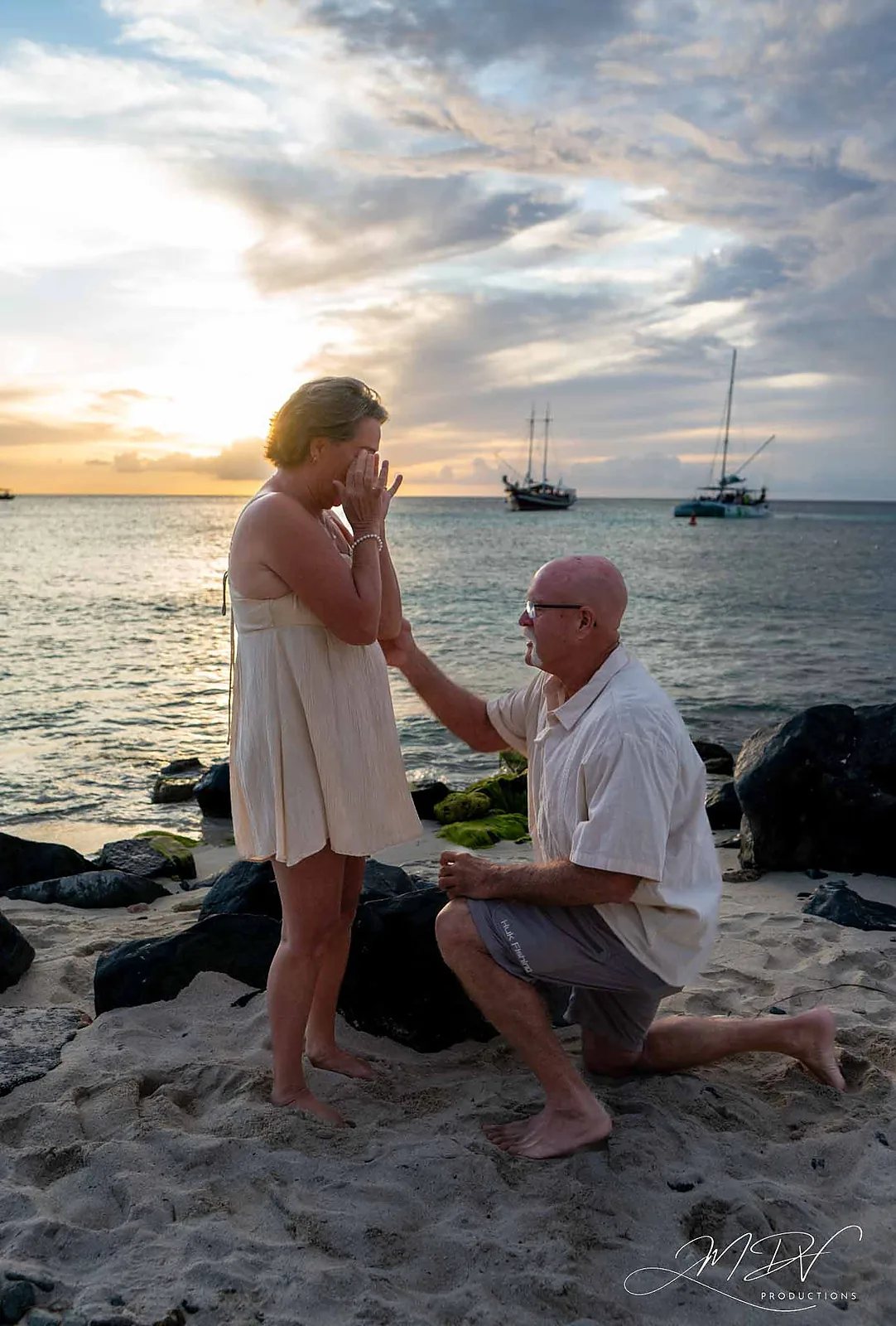 Man on one knee proposing on the beach at sunset in Aruba
