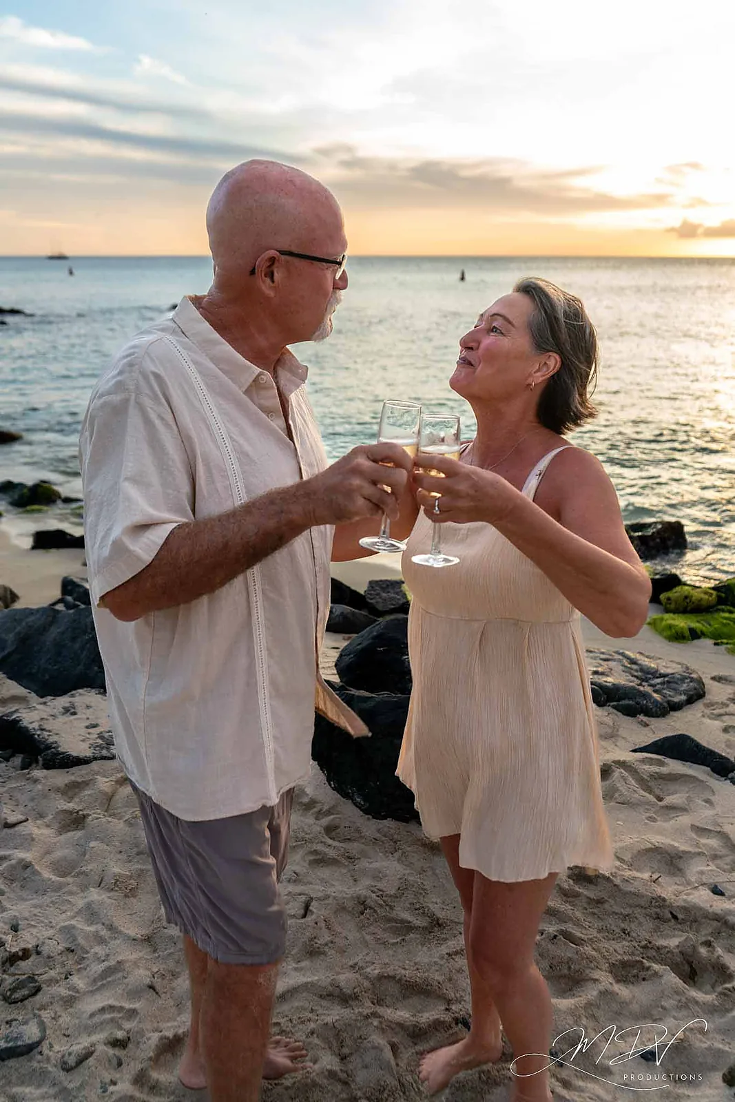 Newly engaged couple toasting with champagne on the beach in Aruba