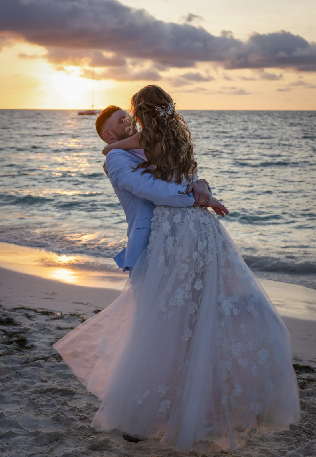 Groom lifting the bride on the beach at sunset in Aruba