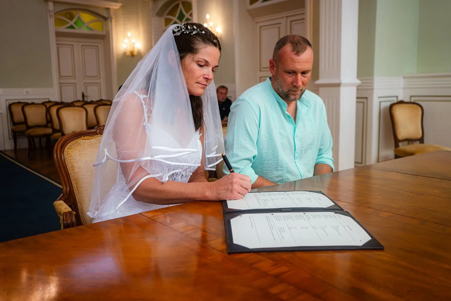 Bride signing the marriage papers next to the groom in Aruba